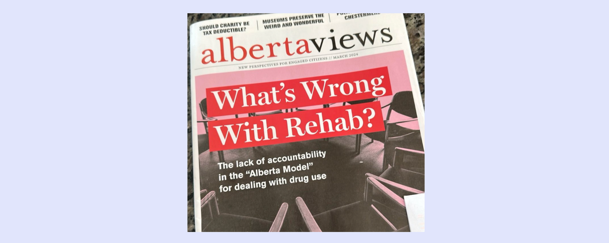 Alberta Views cover story: What's Wrong With Rehab? in white, pink and red, overlaid on a black and white photo of a ring of empty chairs.