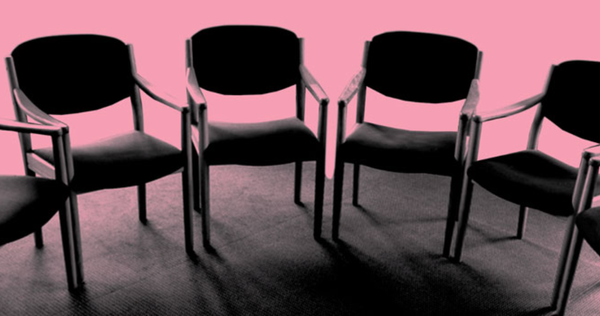 Pink-hued photo of empty chairs arranged in a circle.