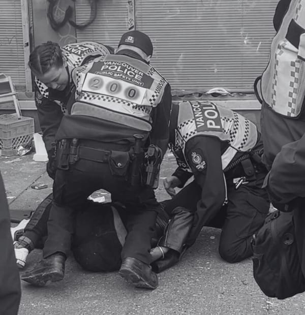 3 police officers kneel on and surround a person lying prone on the sidewalk with one arm at a painful-looking angle.